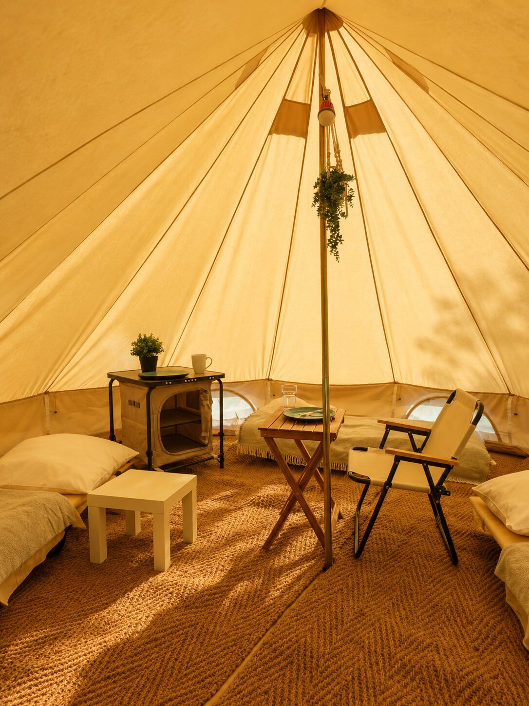 Innenansicht des Glamping-Zelts mit Betten und warmem Licht